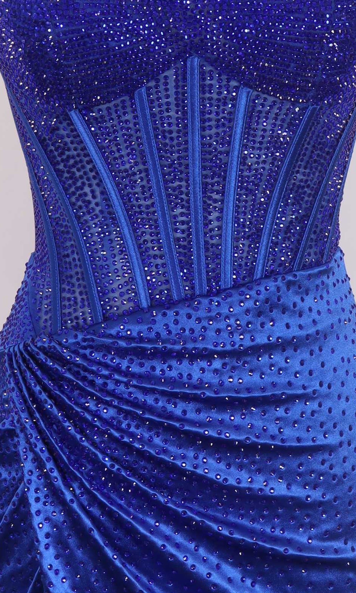 Close-up of the Strapless Hoco Dress: PromGirl Exclusive 250169 in royal blue, showcasing intricate beadwork, structured waist boning, and ruched fabric dotted with rhinestones for a sparkling homecoming look.